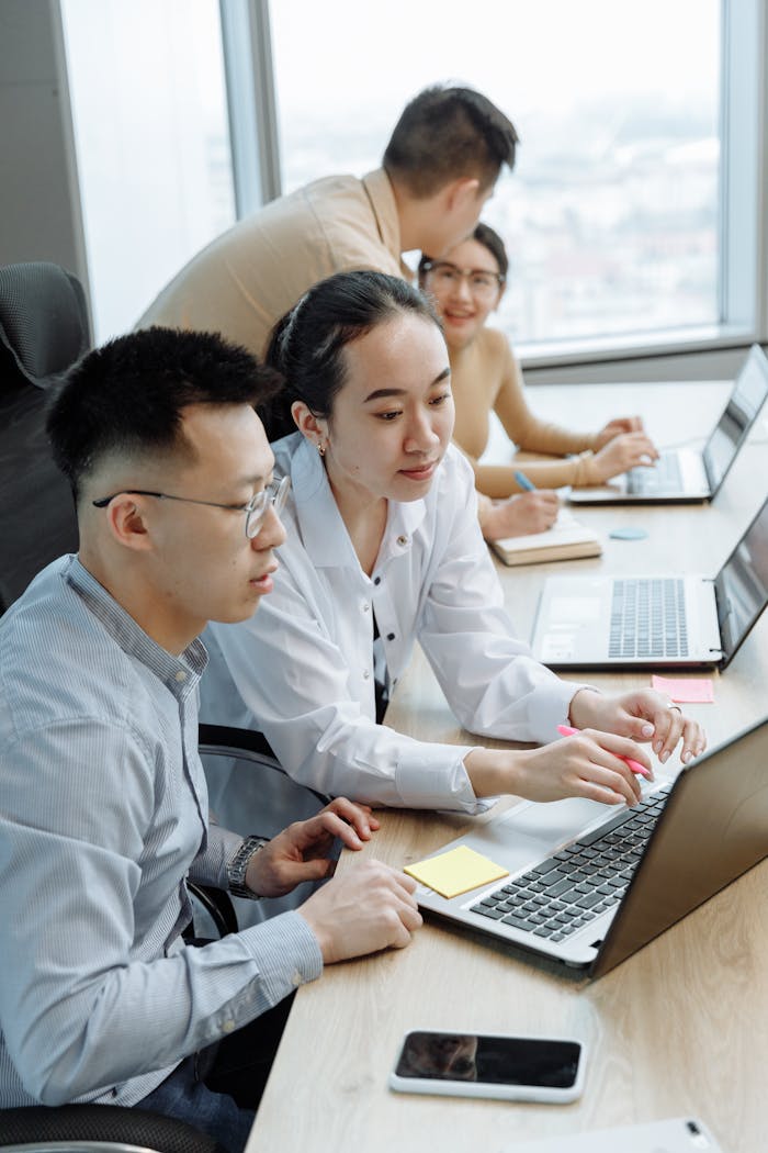 our-story Young professionals collaborating on laptops in a modern office setting.